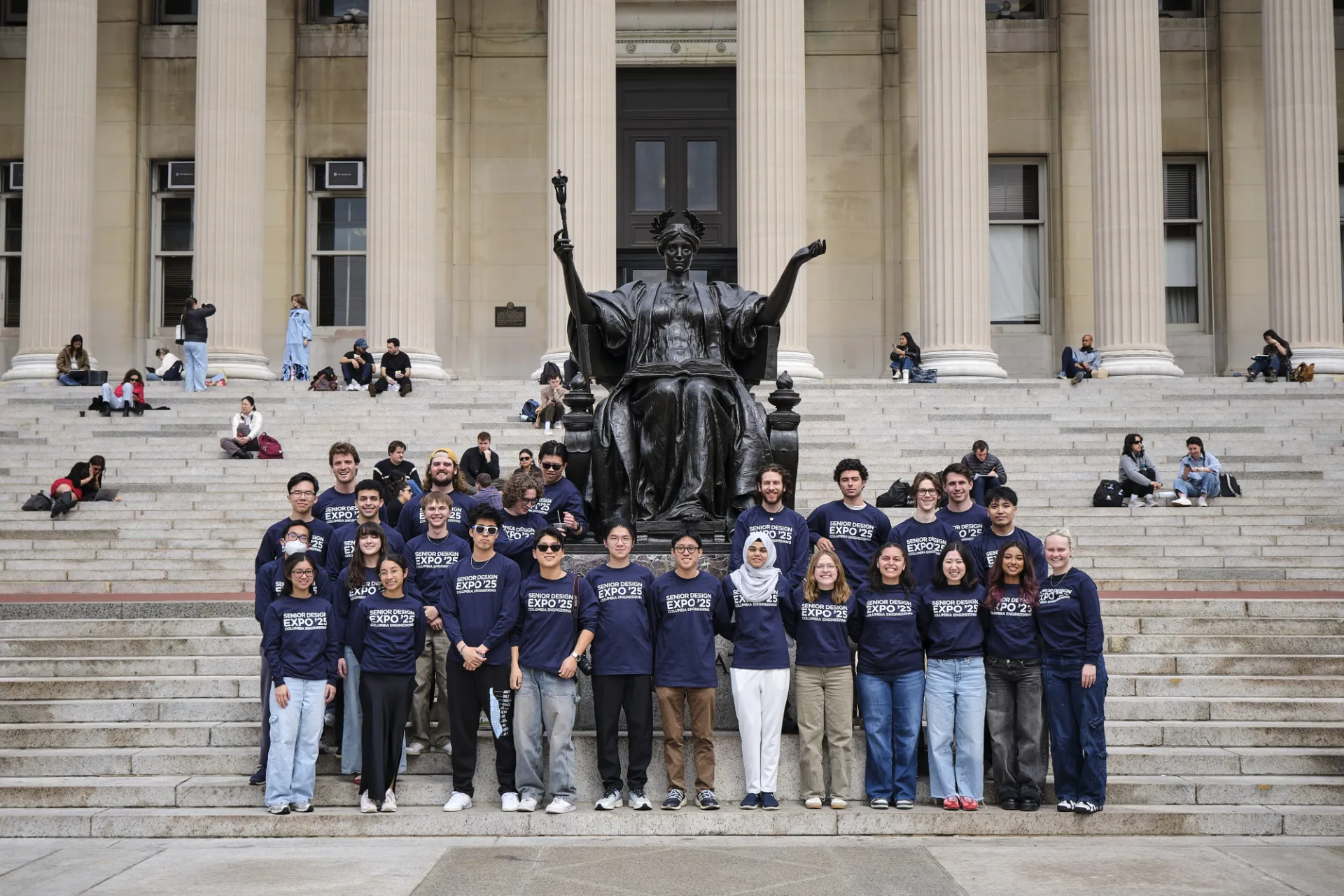 Group of students surrounding Columbia's alma mater statue